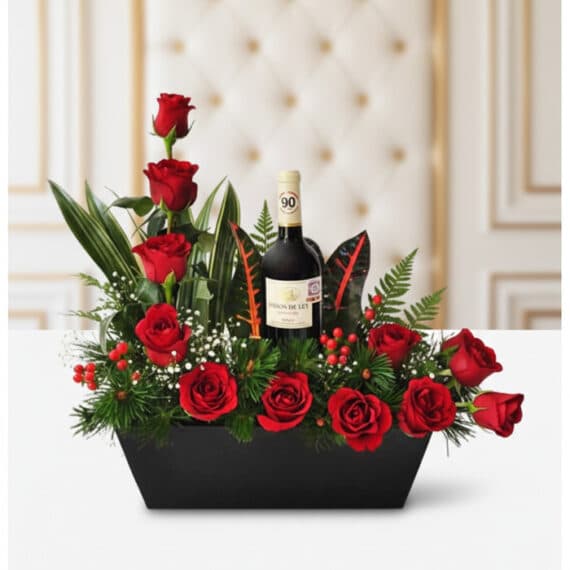 Arreglo Floral CINZIA: Rosas Rojas y Vino, Regalo Elegante Arreglo floral CINZIA con 12 rosas rojas frescas, follaje verde variado y una botella de vino tinto, presentado en una base n