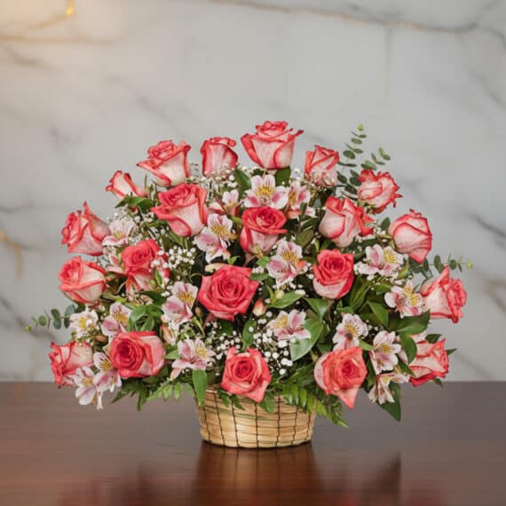 Arreglo Floral Emilia: Rosas Blush Frescas para Regalar con Estilo Arreglo floral Emilia con 32 rosas blush frescas, alstroemerias blancas y follaje verde en una canasta de mimbre sobre una me