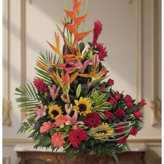 Arreglo Floral IDARA: Diseño Exclusivo con Rosas y Flores Exóticas Arreglo floral IDARA con rosas rojas, girasoles, lirios, heliconias y jengibre rojo en un fondo elegante y bien iluminado.