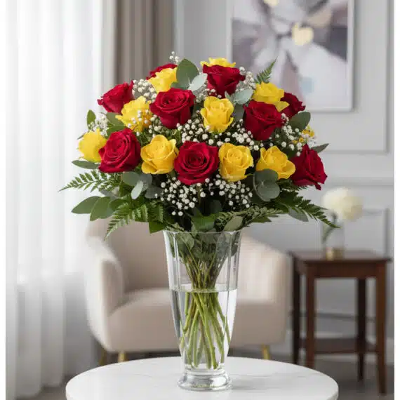 Arreglo Floral LORENZA: 24 Rosas Rojas y Amarillas Llenas de Vida Arreglo floral LORENZA con 24 rosas rojas y amarillas en un jarrón de cristal, sobre una mesa blanca con fondo elegante y luz