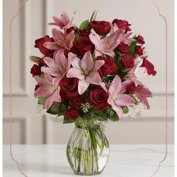 Arreglo Floral Nabila: Majestuoso Ramo de 30 Rosas y Lirios Rosados Arreglo floral Nabila con 30 rosas rojas y lirios rosados en un jarrón de cristal, ideal para ecommerce.