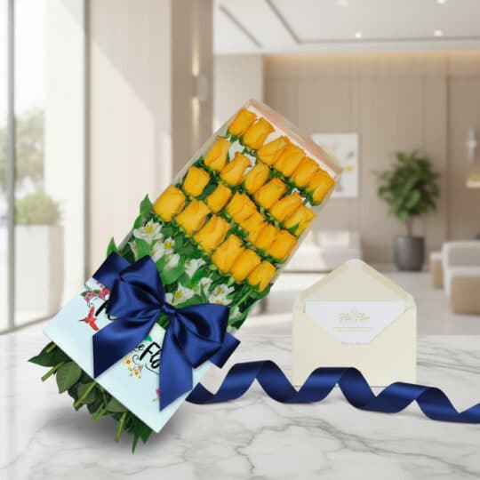 Caja de 24 rosas amarillas frescas y vibrantes, con follaje verde, sobre una mesa de mármol. Incluye una tarjeta de regalo el