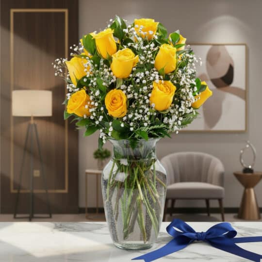 Jarrón de cristal con doce rosas amarillas frescas y gypsophila, sobre una mesa de mármol con un lazo azul marino, en un ambi