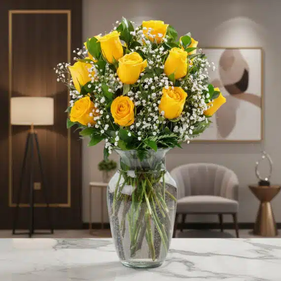 Jarrón con 12 Rosas Amarillas: Frescura y Elegancia para tu Hogar Jarrón de cristal con doce rosas amarillas vibrantes y follaje verde, sobre una superficie de mármol en un entorno de lujo.