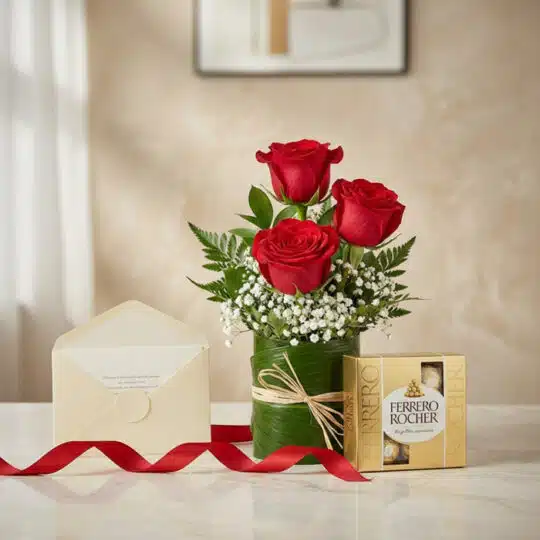 Solitario de tres rosas rojas frescas en jarrón de hojas, acompañado de caja de bombones Ferrero Rocher, tarjeta de regalo y